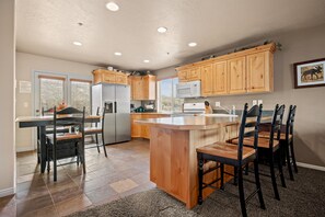 Wooden countertops and natural pine cabinets create a cozy, mountain-lodge feel, while a kitchen bar with seating for three makes the perfect spot for morning coffee or casual meals.