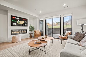 The living room has a large smart TV, electric fireplace, amazing views, and direct access to the deck.