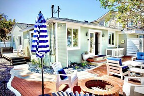 With striped umbrellas, stylish furniture, and a fully fenced layout, it's a charming blend of beachy comfort and relaxed elegance. Ideal for soaking up the sun or enjoying the breeze after a day by the ocean