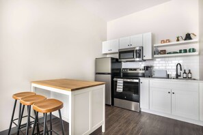 Fully equipped kitchen featuring a kitchen island and seating for three. 