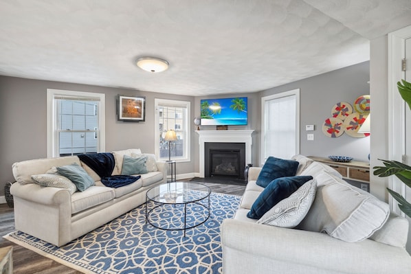 Cozy living room with a Smart TV, gas fireplace, and two comfy couches for a relaxing stay.