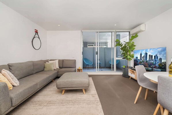 Glass sliding doors open out onto enclosed private balcony