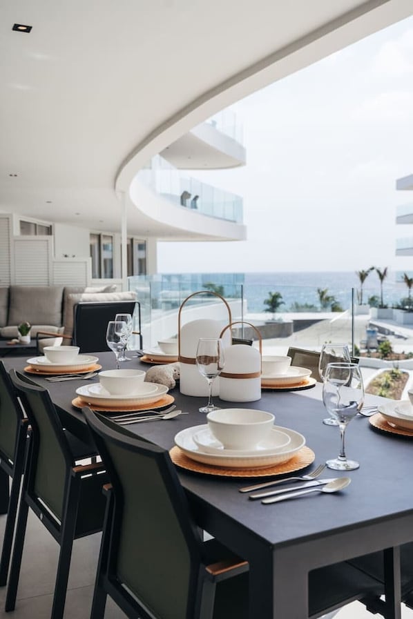 Coastal luxury done right—sleek table settings, soft sea breeze, and a view that whispers, “Stay a little longer.” Perfect spot for sunset dinners and seaside conversations.