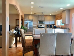 Chef’s kitchen stocked with premium appliances and cookware, plus dining seating for 8—perfect for shared meals and easy cooking.