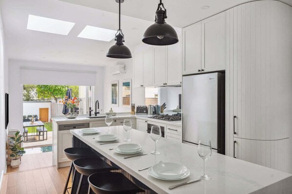 A stylish mix of modern design and classic charm, with white cabinets and black stools making the kitchen a perfect spot to gather.
