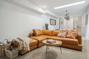 Relax in this stylish ground-floor lounge with a cozy leather sofa, soft lighting, and warm tones—perfect after a day out.