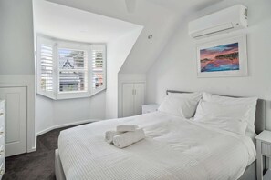 Embrace the calm of a white primary bedroom on Level 1—a harmonious blend of simplicity and elegance, creating a restful retreat.