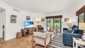 Bright, cozy, and coastal-chic. This inviting living room is the perfect place to unwind after a beach day—featuring comfy seating, tropical touches, and serene views just beyond the sliding doors