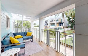 Private balcony surrounded by lush greenery, featuring outdoor dining and seating—perfect for morning coffee, al fresco meals, or evening relaxation.