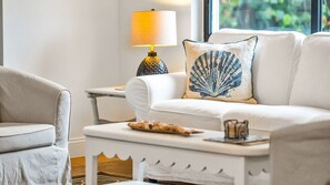 Spacious open floor plan featuring two inviting living room areas, smart TV, books, and games—perfect for relaxing or entertaining. Enjoy seamless access to the kitchen and a private balcony with outdoor dining for four.