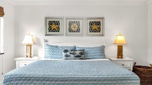 Spacious primary suite featuring a plush king bed, extra large closets, cozy reading chair, and calming coastal decor for the perfect retreat.