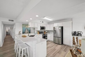 Modern kitchen with stainless steel appliances and a breakfast bar.