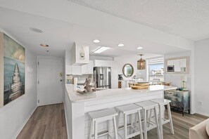 Sleek, modern kitchen with white cabinetry and a breakfast bar.