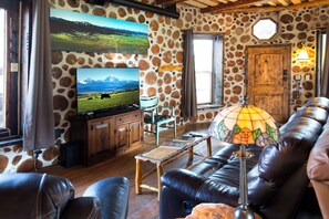 Leather lounge, chairs, and smart TV in living room