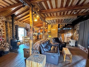 Main living room with vaulted ceilings and wood stove