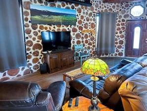 TV living room with 3 leather recliners and panoramic photo by Craig Hergert