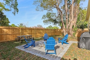 Backyard has a built-in firepit with 4 adirondak chairs, a picnic table and propane grill with propane provided
