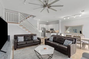Open living room with vaulted ceilings, sleek furnishings, and bright natural light.