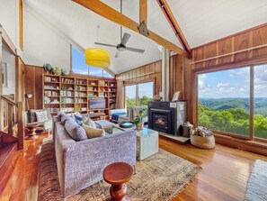 Unwind with a book or a glass of wine in the cedar-lined lounge and library, where floor-to-ceiling windows frame stunning valley views and an open fireplace adds warmth and charm.