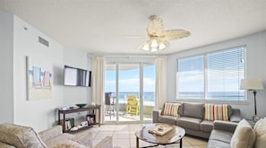 Living Room with BEAUTIFUL Gulf view, balcony access, wall mounted Smart TV and plenty of seating