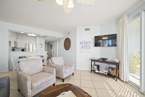 Living Room with BEAUTIFUL Gulf view, balcony access, wall mounted Smart TV and plenty of seating