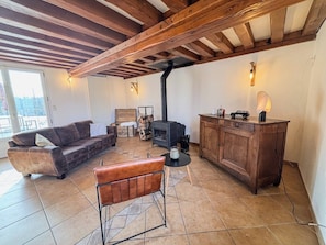 Petit salon pour profiter du feu de cheminée en période hivernale
Poêle à bois
Canapés et fauteuil
Vaisselles dans le placard