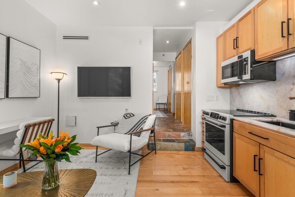 Light-filled, open concept kitchen/living area with smart TV ample seating.