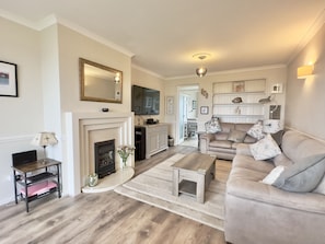 Fireplace and sofas in living room of Curlews, 36 Egerton Road Holiday Cottage, Padstow, North Cornwall