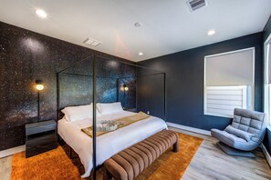 The master bedroom includes an end stool and a modern floor lounge chair