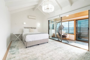 Retreat upstairs to the primary suite, where a queen bed dressed in crisp linen awaits and glass doors open to calming views over the Derwent.