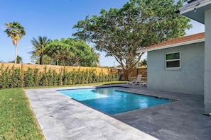 Saltwater swimming pool, deck, dining table, sitting area, grill, fire pit
