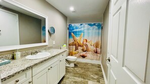 Spacious bathroom 2 with granite countertop and amenities.