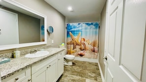 Spacious bathroom 2 with granite countertop and amenities.