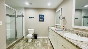 Spacious bathroom 1 with dual sinks and granite countertops.