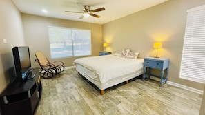 Spacious bedroom 1 with a king bed, side tables, TV, and more.
