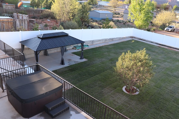 Backyard: Hot tub, covered patio, grass