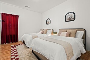 A twin bedroom decorated in creamy tones with flower frames