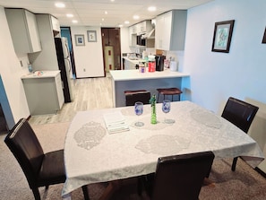 Dining area behind living room. with 2 bar stools and a table set for 4.