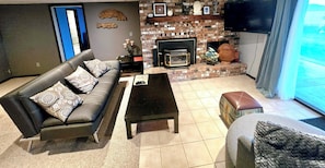 Living room with propane fireplace and waterfront mountain view