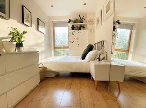 Bedroom 1 with a double bed, chest of drawers and large mirror 