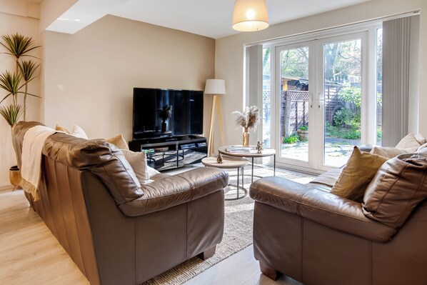 Large living area with comfortable sofas and extra cushions, stools + laptop workstation+ PlayStation + Netflix