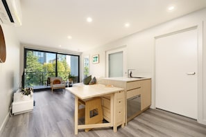 Bright open-plan living with kitchen, dining & balcony access.