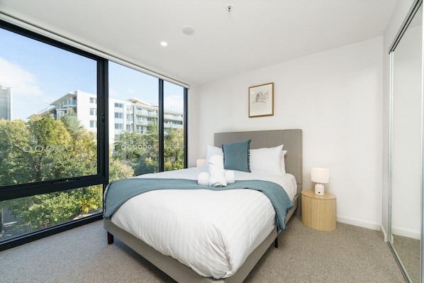 Comfy queen-size bed with professionally laundered linen and plush pillows.