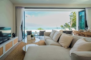 The living room is designed for relaxation and entertainment, featuring a smart TV that provides access to international channels and popular streaming services.
