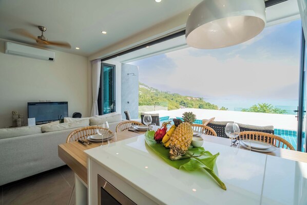 The living room features bi-fold windows that open completely, providing unobstructed views.