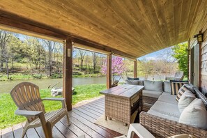 Cozy riverfront deck with plush seating and vibrant nature views.
