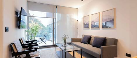 Experience modern comfort in this stylish living room, featuring large windows and a serene view. Perfect for relaxation and unwinding.