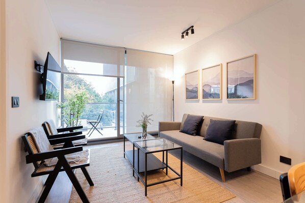 Experience modern comfort in this stylish living room, featuring large windows and a serene view. Perfect for relaxation and unwinding.