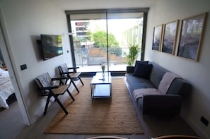 Bright and modern living room with large windows, minimalist decor, and a cozy atmosphere—perfect for relaxation after a day of exploring!