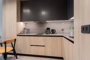 Experience a sleek, modern kitchen with stylish cabinetry and essential amenities for a comfortable stay.
